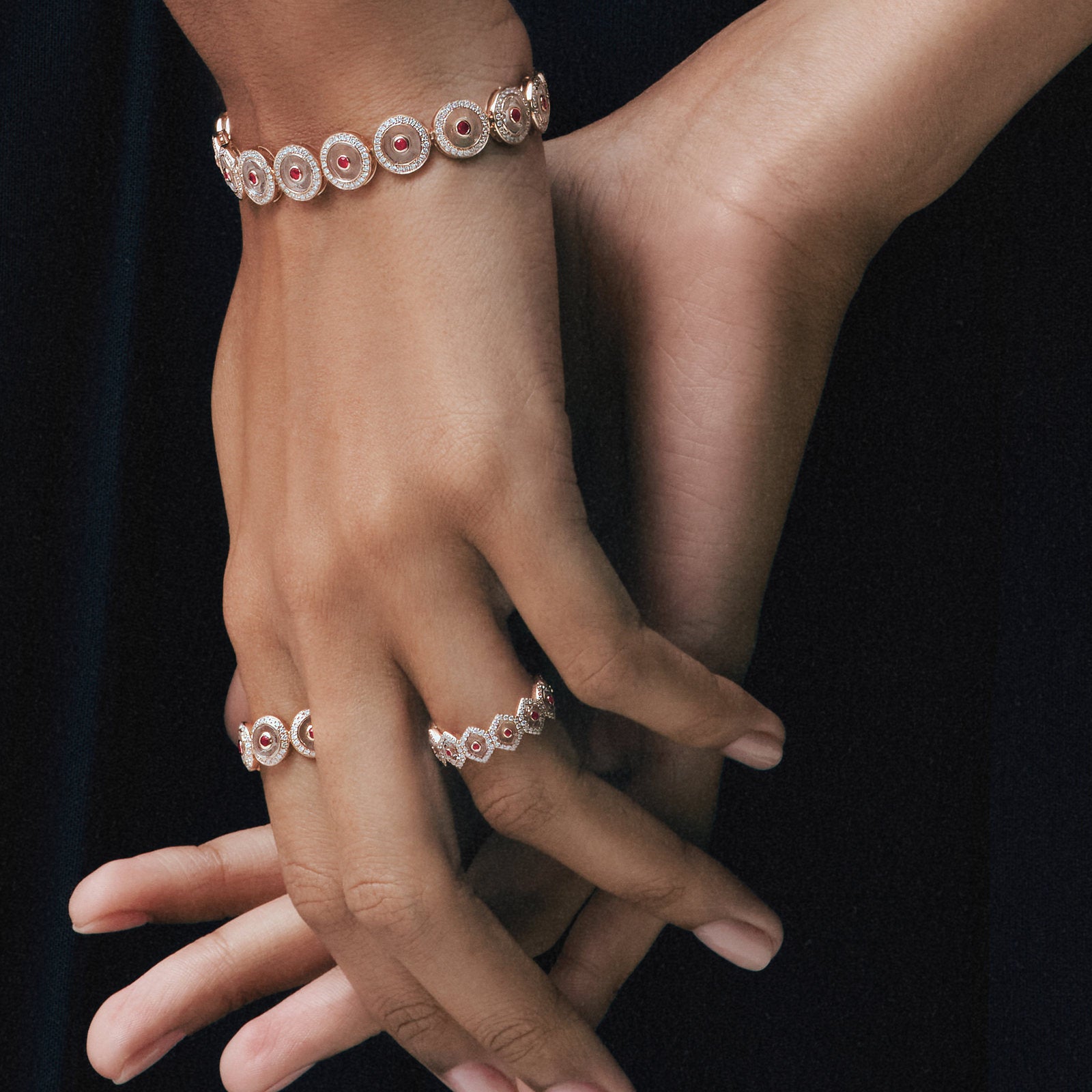 Hands wearing the Ruby Circle Tennis Bracelet and Ruby Circle Eternity Rings