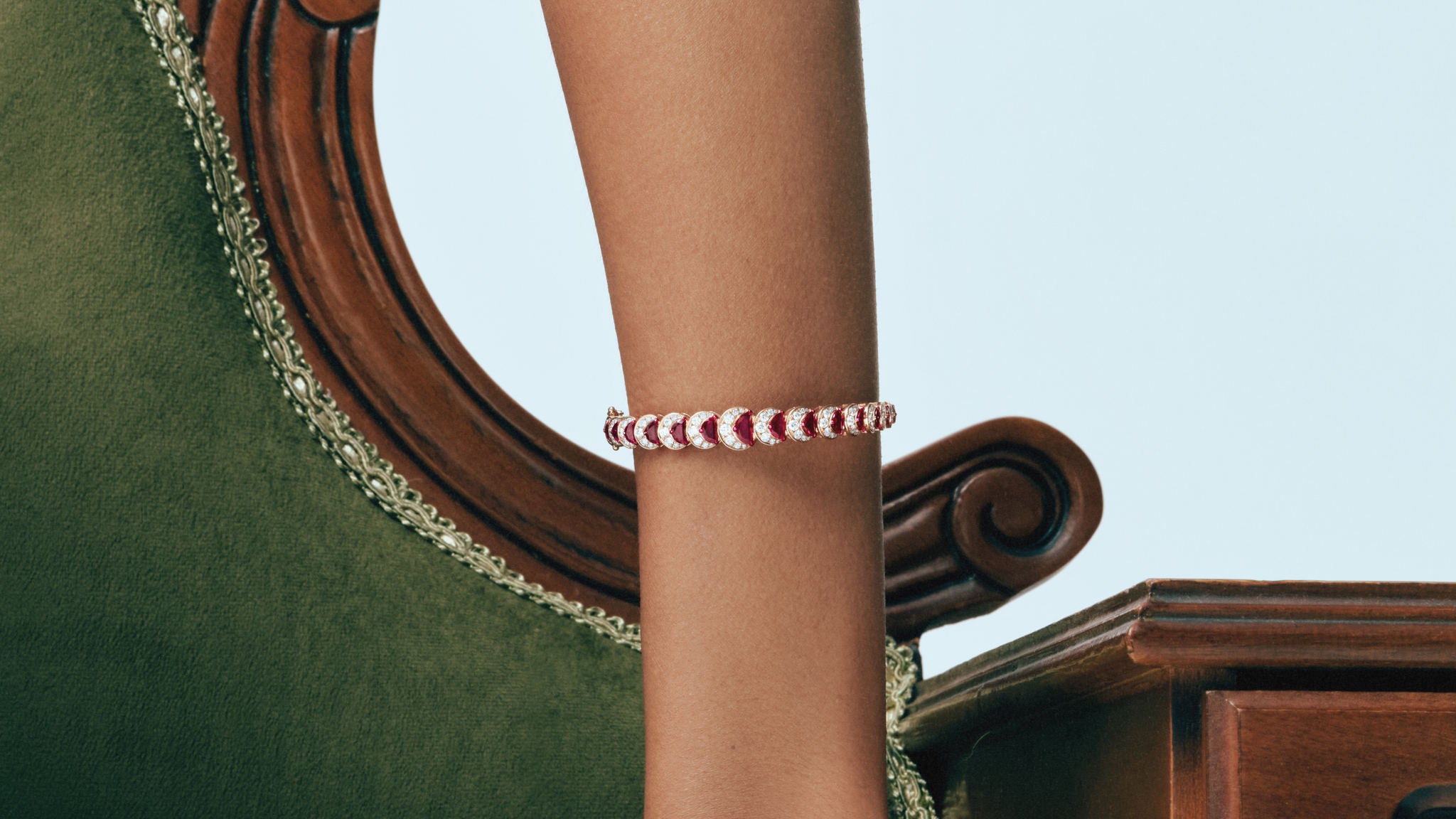 Ruby Crescent Bangle and Ring worn on an antique green velvet chair